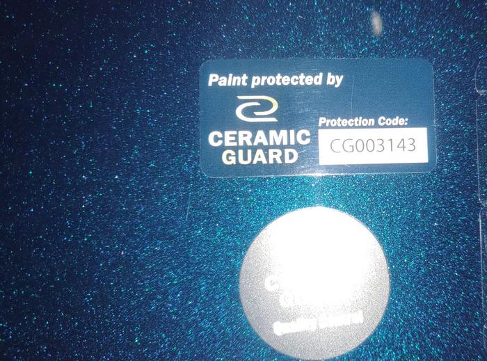 Sticker “Paint protected by Ceramic Guard” met beschermingscode op een behandelde wagen